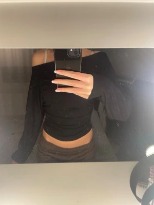 Svart offshoulder topp - Säljer en svart offshoulder topp med lång ärm och croppad passform ifrån lager 157. Basic svart långärmad 