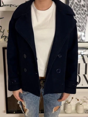 💙marinblå kappa - design by si 💙 - Säljer nu min superfina och klassiska korta kappa/skepparkavaj från det populära märket Design by SI. Nypris var cirka 700kr.   Jackan har en perfekt "oversized men nätt" passform med snygga dubbelknäppta detaljer och dekorativa knappar vid ärmsluten. Den djupa marinblå färgen gör att den passar till precis allt – från jeans till en finare klänning. Ställ gärna frågor om ni funderar över något!❤️ 