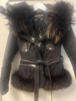 Svart pälsjacka med bälte - Snygg svart jacka med päls och bälte !Nypris 16000