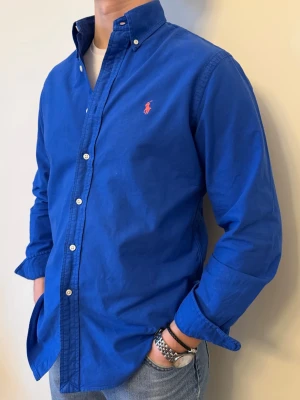 Blå Ralph Lauren skjorta - En snygg polo skjorta som passar till alla tillställningar! En stark blå färg som lämnar ett avtryck. Inga deffekter och casual fit. Storlek👔: M Nypris💰: ca 1399 kr