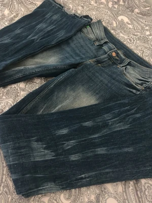 Blå bootcut jeans från Cheap Monday - Säljer ett par blå jeans från Cheap Monday med bootcut-snitt och slitna detaljer vid bensluten. Storlek 29/32, inga defekter🩷