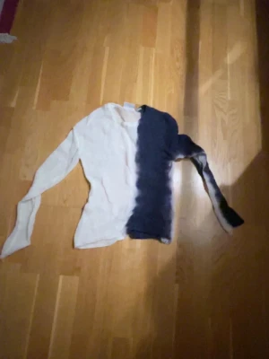 Weekday stickad tvåfärgad tröja S - Säljer en tunn stickad tröja från Weekday i storlek S. Tröjan har en cool tvåfärgad design med ena sidan vit och andra sidan mörkblå, samt långärmad passform. Perfekt för dig som gillar unika plagg och vill sticka ut lite extra.
