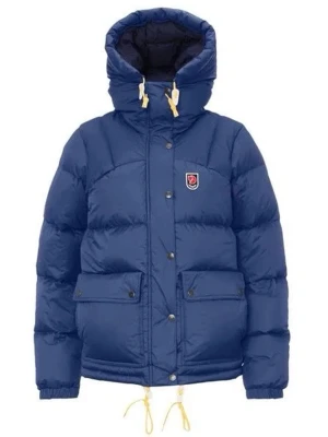 Blå dunjacka från Fjällräven - Blå dunjacka från Fjällräven med stor huva, gula snören och klassisk logga på bröstet. Jackan har två stora fickor med knappar, dragkedja och tryckknappar framtill. Perfekt för kalla dagar och har en schysst, puffig look. Helt ny helt, oanvänd, inga märken eller ngt. Kvitto och förpackning saknas