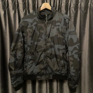 Woolrich windbreaker  - Woolrich windbreaker - skick 8/10, fint skick med knappt några defekter! - storlek EU Medium, men passar S - sjuuukt snygg windbreaker till våren med de blåa camouflaget - ända ”defekten” kan vara att texten suddats ut lite på badgen (bild 3) - hör av er vid frågor🙌