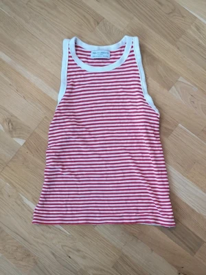 Randigt linne - Röd och vit randigt linne från Holly & Whyte by Lindex i storlek M. Toppen har röda och vita smala ränder, breda axelband. 