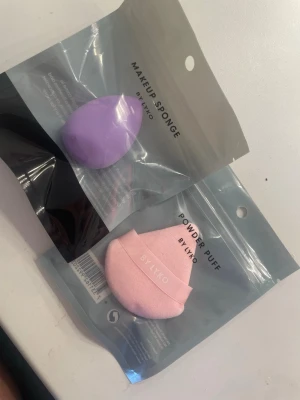 Makeup sponge & powder puff från Lyko🫶🏻 - Säljer ett set med en lila makeup sponge och en ljusrosa powder puff från Lyko. Makeup-svampen är droppformad och vegansk, perfekt för att blenda foundation, concealer eller primer. Powder puffen är mjuk och trekantig med band för grepp, idealisk för att applicera puder. Helt nya! En för 25 eller båda för 40🤍