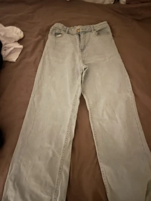 Ljusblå jeans från Lindex med fransad kant - Säljer ett par ljusblå jeans från Lindex i storlek 164. Modellen har raka ben och fransad kant längst ner för en cool touch. Klassisk femficksdesign och hög midja. Perfekta för dig som gillar avslappnad stil och denim.