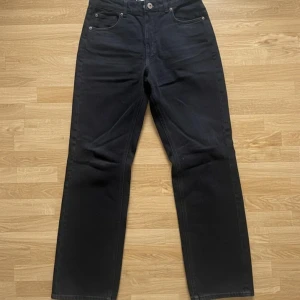 Svarta midwaist mom jeans från H&M, strl 40 - Säljer ett par svarta jeans från H&M i storlek 40. Modellen har raka ben och klassisk femficksdesign. Jeansen är tillverkade i bomull och har normal midja. Perfekta om du gillar en avslappnad stil.