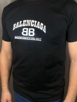 Svart t-shirt med tryck - . Klassisk passform och rund hals. Perfekt för dig som gillar streetwear och vill ha något stilrent från ett lyxigt märke.