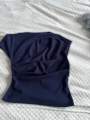 Mörkblå axelbandslös topp Floreya - Trendig mörkblå axelbandslös topp från Floreya. 