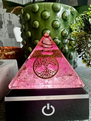 Orogonitpyramid rosenkvarts  - En orgonitpyramid fylld med rosenkvarts, kopparspiral och symbolen Livets träd. Skapad för att harmonisera energier, stärka självkärlek och skapa ett lugnt, balanserat rum.  ✨ Energi & betydelse  💗 Rosenkvarts – kärlek, trygghet och emotionell läkning 🌳 Livets träd – balans, tillväxt och kontakt mellan kropp, själ och sinne 🌀 Kopparspiral – förstärker och cirkulerar energin ✨ Orgonit – renar stagnerad energi och höjer vibrationer  Alla kristaller jag lägger upp här är egenimporterat 