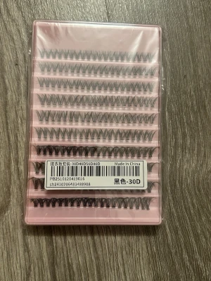Individuella lösögonfransar svart 30D - Ett set med individuella lösögonfransar i svart, packade i en rosa plastförpackning. Fransarna är i 30D-utförande och har en naturlig böjd form för att ge volym och längd till dina egna fransar. Perfekt för att skapa en personlig look och anpassa mängden volym. Aldrig använd nyskick, PRISET GÅR ATT DISKUTERA