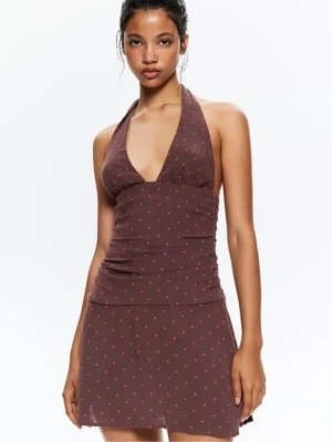 Brun halterneckklänning  - Snygg brun kortklänning från PULL AND BEAR med halterneck och små röda prickar. Klänningen har en åtsittande passform upptill och lätt utställd kjol. Perfekt för dig som gillar en trendig och ungdomlig stil. Storlek XL men sitter som M aldrig använd 
