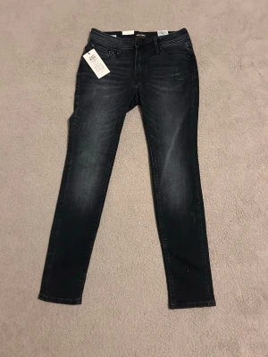 Mörkblå skinny jeans från Cubus - Snygga mörkblå skinny jeans från Cubus med klassisk femficksdesign och stretchigt denimtyg. Jeansen har smal passform och subtila slitningar framtill för en trendig look. Perfekta för dig som gillar en tajt siluett och stilren känsla.