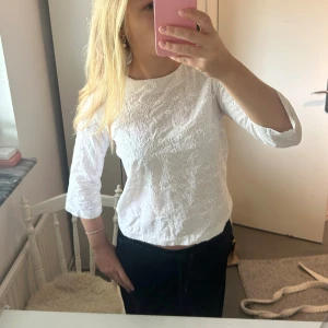 Vit blus med broderade detaljer - Säljer en söt vit blus med broderade blommönster och trekvartsärm. Blusen har en rak passform och är tillverkad i bomull, vilket gör den både luftig och bekväm. Köpt från sellpy men från GANT. Stl S