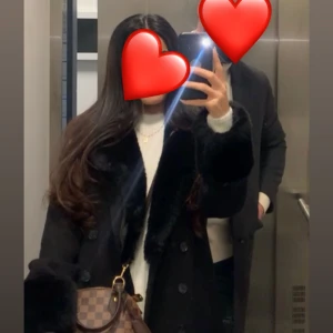 Svart kappa med fuskpälsdetaljer - Säljer en svart lång kappa med bred krage och ärmslut i mjuk fuskpäls. Kappan har dubbelknäppning framtill. Från Chiara Forthi. Strl 34 men oversized! Nypris 1699kr