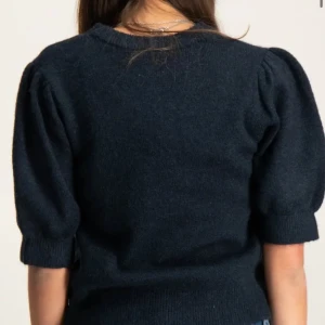 Mörkblå stickad tröja med puffärm - Snygg mörkblå stickad tröja med puffade korta ärmar och rund hals. Tröjan har ribbade muddar vid ärmslut och nederkant, vilket ger en schysst passform. Perfekt att matcha med jeans eller kjol för en cool look. Aldrig använt (dåligt ljus på bilden)