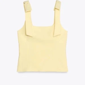 Gul linnetopp med knytband från Zara - Supersöt ljusgul linnetopp från Zara med breda axelband som knyts i rosetter. Toppen har rak halsringning och är figurnära i modellen. Perfekt för dig som gillar en enkel men ändå trendig look. Materialet är mjukt och stretchigt för extra komfort. Använd 1 gång!! Pris diskuteras vid snabb affär 💕💕