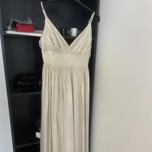 Champagnefärgad balklänning - Superfin balklänning/festklänning. Bra skick men har lite fläckar på insidan och någon fläck på utsidan som inte syns så mycket (kan skicka bild) från förra ägaren. Från bubbleroom. Kostar från början ca 1100.