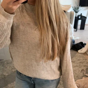 Beige ribbad stickad tröja - Mysig beige stickad tröja med ribbad struktur och rund halsringning. Tröjan har långa ärmar och en avslappnad passform som passar perfekt till jeans. Enkel och stilren design som är lätt att matcha. Storlek vet jag tyvärr inte, men passar mig bra som vanligtvis oftast har S. märket heter cache.