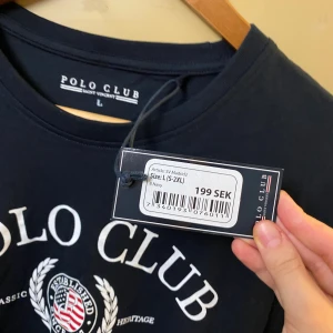Mörkblå Polo Club t-shirt  - Helt ny oanvänd snygg mörkblå t-shirt från Polo Club Saint Vincent i storlek L. Klassisk passform med vit logga och emblem framtill. Skön rund hals och korta ärmar. Perfekt för dig som gillar stilren och sportig look.