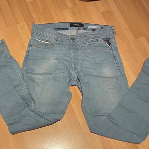 Replay Grover ljusblå jeans - Säljer ett par Replay Grover jeans i ljusblå tvätt med straight fit. Klassisk femficksmodell med dragkedja och Replay-logga på fickan. Jeansen är tillverkade i mjukt denimtyg och har en snygg, avslappnad look.