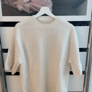 Vit stickad tröja med kort ärm - Supermjuk vit stickad tröja med korta ärmar och rund halsringning. Strl Xs, men har en oversized passform, så passar både S och M skulle jag säga!💕🤩