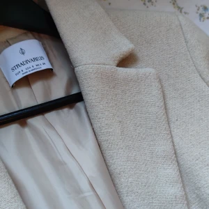 Beige kappa från Stradivarius - Stilren och lång beige kappa från Stradivarius med klassisk krage och helfodrad insida. Kappan har rak passform och är tillverkad i ett mjukt tyg med diskret struktur. Färgen gör sig mer tillrättavisa på bild 1. Storlek S. Finns även band till som man knyter kappan med. Pris kan diskuteras vid snabb affär 🤗💗