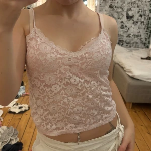 Pastellfärgad spetslinnetopp med blommor - Säljer två croppade linnetoppar i spets, en ljusrosa och en ljusgrön. Båda är i stl 34, säljer båda för 150kr och en för 100kr