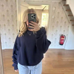 Mörkblå oversized sweatshirt - Säljer en mörkblå oversized sweatshirt med rund hals och långa ärmar. Tröjan har breda muddar vid ärmslut och nederkant, vilket ger en chill och avslappnad vibe. Perfekt för dig som gillar en loose fit och enkel stil.