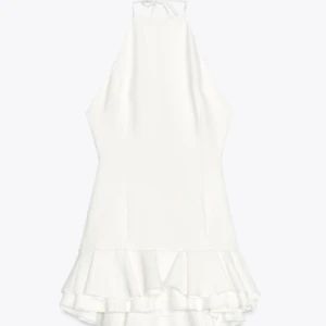 Vit kort klänning med volang - Supersöt vit kort klänning med volangkant nertill och figurnära passform. Klänningen är ärmlös och har en stilren, enkel design som känns både fräsch och trendig. Perfekt för sommarens alla tillfällen! Från Zara, helt slutsåld nu, nypris runt 550 kr, öppen i ryggen, använd endast under student mottagningen 