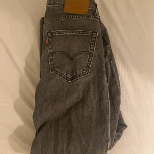 Grå Levi's 511 jeans W30 L32 - Säljer ett par grå Levi's 511 jeans med klassisk femficksdesign och snyggt slitna detaljer. Jeansen har en slim passform och är tillverkade i mjukt denimtyg. Perfekta för dig som gillar en stilren och avslappnad look.