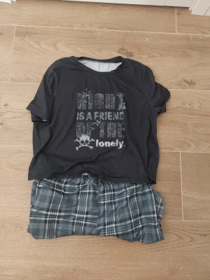 Pjamas set från ROMWE i blå toner - Säljer ett pyjamas set  från ROMWE i blå och grå toner. Byxorna har ett klassiskt rutmönster och är gjord i ett mjukt material som känns skönt mot huden.