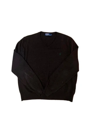 Mörkbrun v-ringad tröja Polo Ralph Lauren - Klassisk mörkbrun v-ringad tröja från Polo Ralph Lauren. Tröjan har lång ärm och diskret broderad logga på bröstet. Perfekt att bära över skjorta för en clean och stilren look. Tillverkad i mjuk ull som känns skön mot huden.