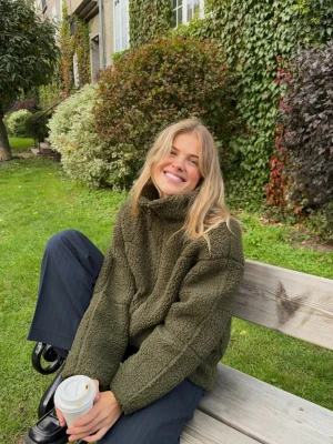 Olivgrön teddyjacka med dragkedja - Mysig olivgrön teddyjacka med oversized passform och hög krage. Jackan har hel dragkedja framtill. Helt ny, aldrig använd. Nypris 500kr😊