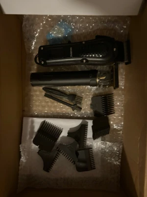 Inga västar på bilderna - Bilderna visar hårtrimmers och tillbehör, ingen väst syns. Laddare kommer med 