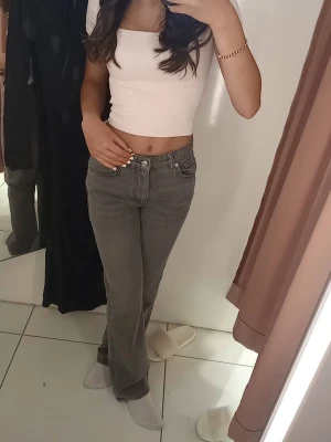 Gråa straight jeans från Gina Tricot  - Säljer ett par gråa jeans från Gina Tricot i rak modell. De har klassisk femficksdesign, dragkedja och knapp framtill samt bälteshällor. Jeansen är i ett mjukt bomullsmaterial och har en snygg tvättad look som passar till allt.