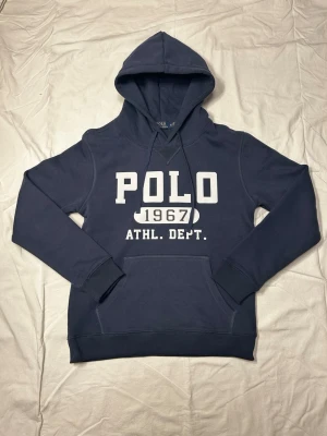 Polo Ralph lauren hoodie - Säljer en mörkblå polo ralphlauren hoodie. Storleken på hoodie är M men sitter mer som än S( funkar även som en M). Modellen på bildens är 183 o väger 70 kg. Skriv vid minsta fundering.