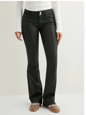 Nelly skinnbyxor  - Svarta ”coated lowaist stitch jeans” från Nelly med låg midja och bootcut-ben. Byxorna är helt nya och köpt i fel storlek så kan även byta mot ett par i st 36💘 De är helt slutsålda 