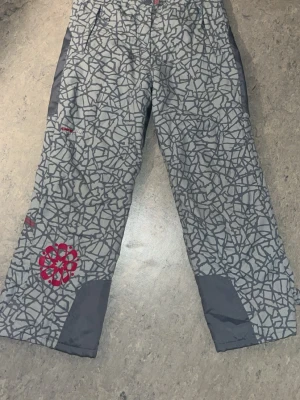 Termobyxor - Grå oanvända termobyxor från Girl Hipe i storlek 146, med fleecefoder på insidan. Reflex samt unikt mörkgrått mönster och detaljer i rosa. Två fickor framtill och justerbara vid ankeln. Pris kan självklart diskuteras, tveka inte att höra av er vid frågor🤍