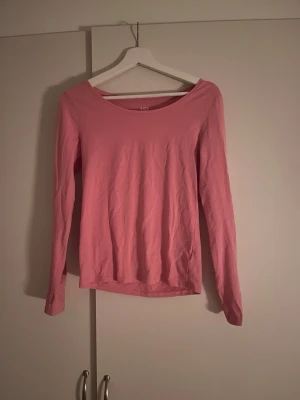 Rosa långärmad topp från 157 - En enkel och mjuk rosa långärmad topp från 157. Tillverkad i bomullsmix med rund halsringning och rak passform. Perfekt basplagg att styla med jeans eller kjol.