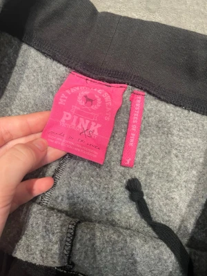 Svarta mjukisbyxor från PINK XS - Svarta mjukisbyxor från PINK by Victoria's Secret i storlek XS. Byxorna har resår och snörning i midjan, samt glittriga detaljer med texten 'Pink A-LISTERS' bak och en liten glittrig hund framtill. Tillverkade i mjuk bomullsblandning för extra komfort. (please make me offers and please contact me in english 😊”