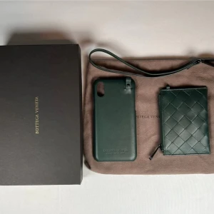 Grön plånbok och iphone skal från Bottega Veneta - Säljer en stilren grön plånbok och iphone skal från Bottega Veneta i exklusivt skinn med det klassiska flätade mönstret. Perfekt storlek för kort och sedlar, med dragkedja och elegant design. Kommer med originalbox och dustbag.