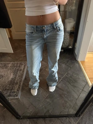 Ljusblå baggy jeans - Blå baggy jeans från H&M i storlek 38. Låg midja och avslappnad passform. Fint skick förutom att de är lite nedtrampade. Säljs då de inte längre kommer till användning.