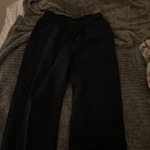 Svarta mjukisbyxor från Gina Tricot XS - Svarta mjukisbyxor från Gina Tricot, basically basics-kollektionen. Byxorna har dragsko i midjan och raka ben. Perfekta för chill dagar eller när du vill vara bekväm. Klassisk och enkel design som funkar till allt.