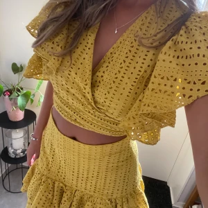 Gul volangkjol och too med broderade detaljer - Säljer ett superfint sett. Kjolen är i storlek M och toppen är storlek L