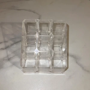 Transparent smyckesförvaring eller hållare  - Snygg och praktisk sminkborsthållare eller smyckesförvaring i transparent med nio fack. Perfekt för att organisera sminkborstar, läppennor eller andra små sminkprylar på sminkbordet. Mått ca 9x9 cm och stilren design som passar alla rum.