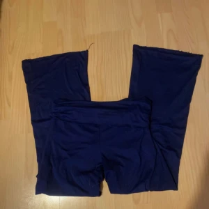 Mörkblå leggings med bootcut - Mörkblå leggings med bootcut och hög midja. Byxorna är stretchiga och sitter tight upptill men har utsvängda ben. Perfekta för en chill och avslappnad look. Tillverkade i mjukt och bekvämt material som känns skönt mot huden.