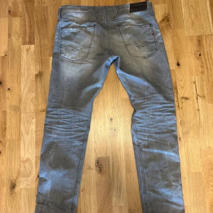 Replay ljusgråa jeans herr - Säljer ett par Replay  jeans med skit snygg tvätt och slitningar. Det är en gammal modell på byxorna och den enda defekten är hålet i skrevet. Kom med frågor