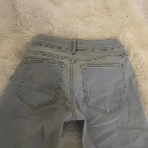 Bootcut lågmidjade ljusblå jeans från &Denim - Bootcut jeans i ljusblå denim från &Denim, modell med låg midja och klassiska fem fickor. Snygga sömmar och bälteshällor, perfekta för en avslappnad och trendig look. Stängs med dragkedja och knapp framtill.